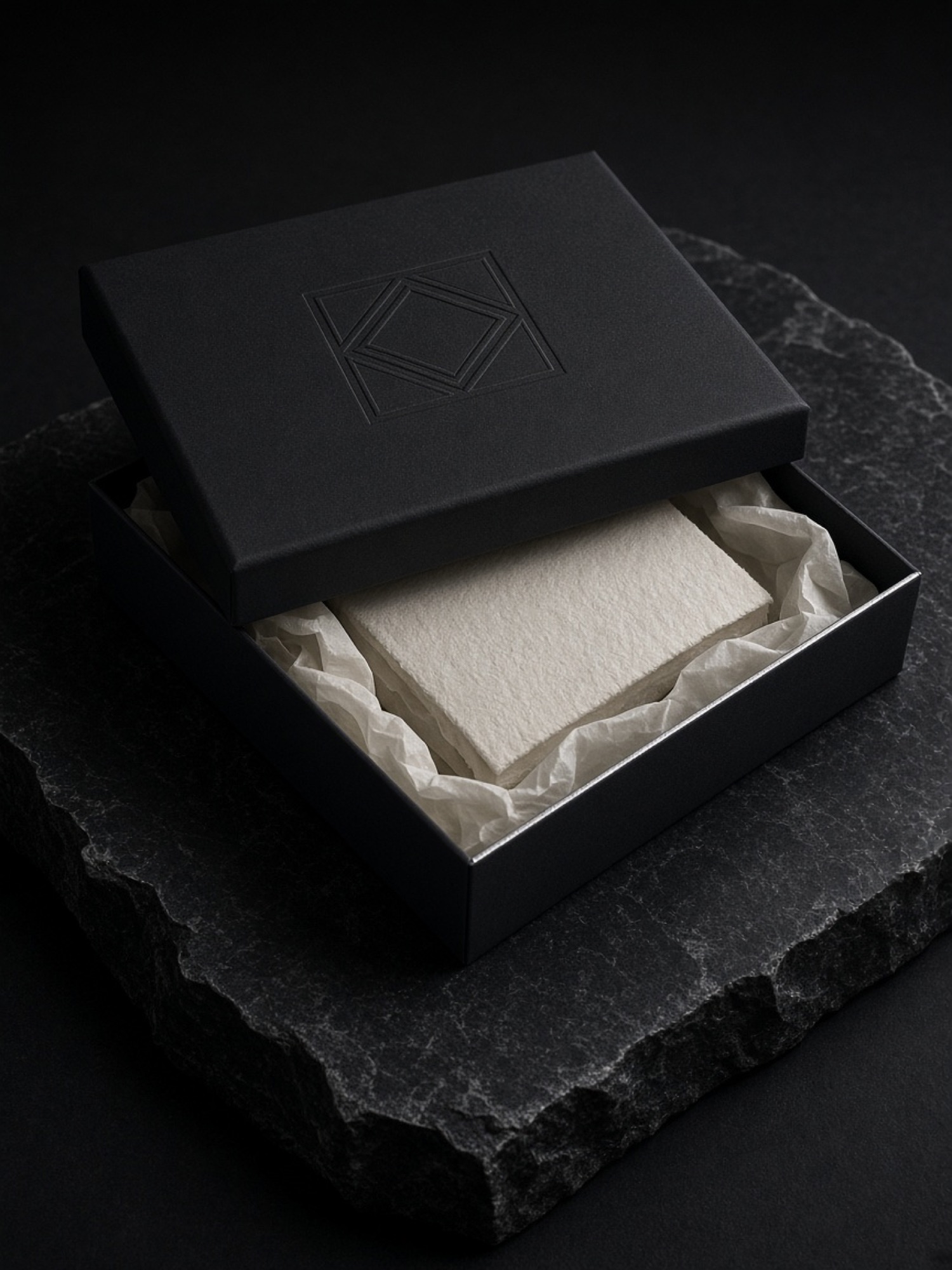 Black rigid box with blind embossing on dark stone